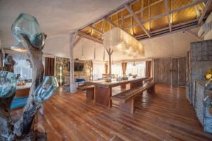 a large room with a table and a tree in it at Summer Bungalow, Ideal for Families, One Room with 2 Beds, Separated Sleeping Corner, Shower, AC, 2 TVs in Lakahembi