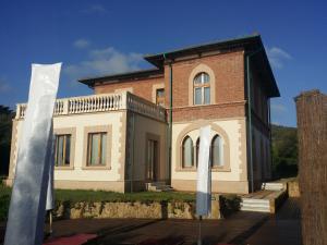 a large brick building with a flag in front of it at Cala Dei Mori in Livorno