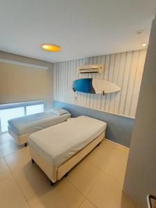 a room with two beds in a room at Casa com 3 suítes em condomínio com piscina em Juquehy in São Sebastião