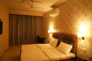 a bedroom with a large bed with white sheets and pillows at Northern view in Chandīgarh +4 photos