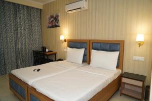 a bedroom with a large bed with white sheets at Northern view in Chandīgarh