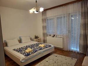 a bedroom with a large bed in a room with windows at Jasmir in Bihać