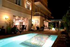 uma piscina em frente a um edifício à noite em Hotel VdB NEXT em Catânia