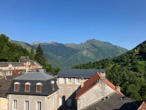 a group of buildings with mountains in the background at Cosy and bright apartment in Eaux-Bonnes center in Eaux-Bonnes