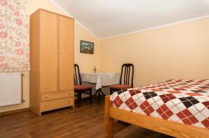 a bedroom with a bed and a table with chairs at Кімнати в центрі in Uzhhorod