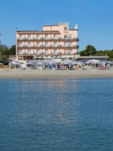 ein großes Hotel am Strand mit dem Wasser in der Unterkunft Hotel Dea in Milano Marittima