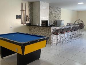 a pool table in a room with a row ofools at Pousada Império in Chapada dos Guimarães