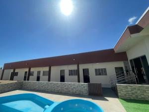 a building with a swimming pool in front of it at Pousada Império in Chapada dos Guimarães