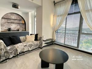 a living room with a couch and a table at Black White Sea Salt Theme Midas Seri Alam in Masai