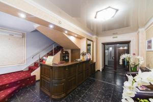 a hotel lobby with a counter and a staircase at Hotel Uyut in Surgut