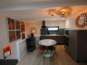 a kitchen with a table and chairs in a room at Logis du Grand in Champlay