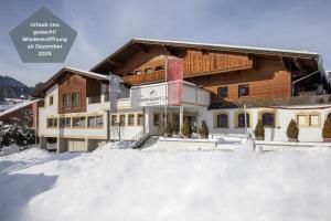 布里克森谷地霍普夫加尔滕Das Hopfgarten Aparthotel的前面有雪的大建筑
