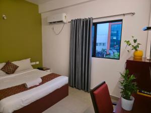 a hotel room with a bed and a window at Sulthan Hotel & Restaurant in Cochin