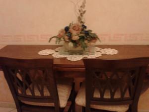 Una mesa de madera con un jarrón de flores encima. en B&B al Corso, en Tarquinia