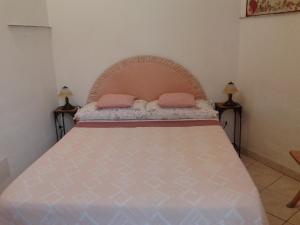 a bedroom with a bed with two pink pillows on it at B&B al Corso in Tarquinia