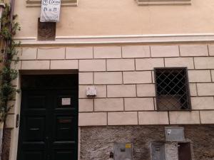 タルクイーニアにあるB&B al Corsoの黒いドアと窓が2つある建物