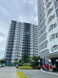 people standing in front of a large apartment building at RJ Elite Escape 2BR Condo w balcony near SM Iloilo in Iloilo City