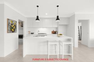 Una cocina blanca con fregadero y encimera. en Serenity on the Green, en Sussex Inlet