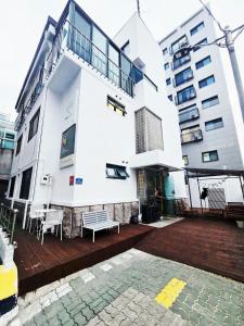 a white building with a deck in front of it at White Green Guesthouse in Seoul