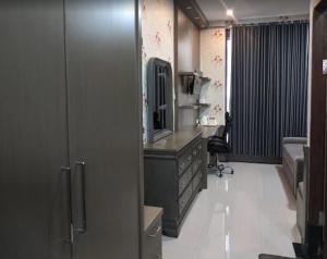 a room with a dresser and a desk with a mirror at Harmadha Suite in Magetan