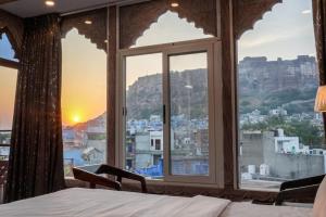 1 dormitorio con ventana y vistas a la ciudad en The Raj Heritage, en Jodhpur