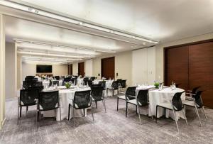 uma sala de conferências com mesas brancas e cadeiras pretas em Hyatt Centric Times Square New York em Nova Iorque