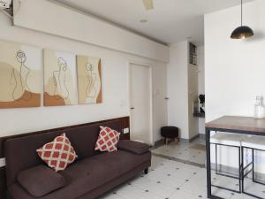 a living room with a couch with two pillows on it at Casa Mel in Pondicherry