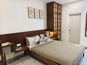 a bedroom with a large bed and a table at Casa Mel in Puducherry