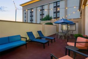 eine Terrasse mit Stühlen, einem Tisch und einem Sonnenschirm in der Unterkunft Hampton Inn Buffalo-Airport Galleria Mall in Cheektowaga