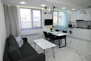 a living room and kitchen with a couch and a table at Spacious and quiet, Komitas 42 in Yerevan