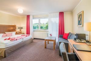 ein Hotelzimmer mit einem Bett und einer Couch in der Unterkunft Best Western Hotel Brunnenhof in Weibersbrunn + 37 Fotos