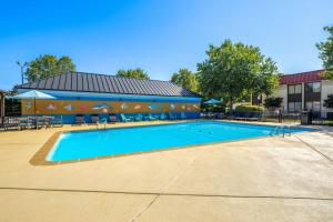 a large swimming pool in front of a building at Village Inn Clemmons-Winston Salem, Trademark by Wyndham in Clemmons