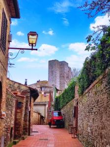 una calle con un semáforo y un castillo en el fondo en Sangi Home, en San Gimignano