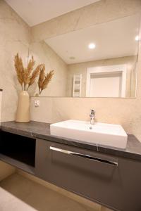 a bathroom with a sink and a mirror at Luksusowy apartament 431 Baltic Spa in Międzyzdroje