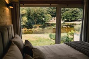 a bedroom with a large window looking out at a field at Apartamentos Herança do Vez in Arcos de Valdevez