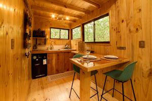 a kitchen with a table and chairs in a cabin at Loft Aneley Refugio Romántico con Tinaja Caliente Privada e ilimitada in Algarrobo