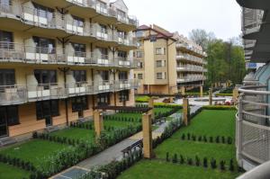 un edificio de apartamentos con jardín frente a él en Apartament Motyl, en Świnoujście