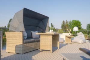 a patio with a chair and tables on a deck at Lieblingsplatz Parey - schwimmendes Hausboot in Parey