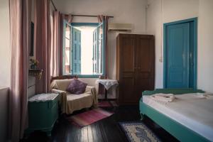 a small room with two beds and a window at Pension Nora in Chania +22 photos
