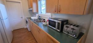 a kitchen with a counter with a microwave and a sink at 2 Bedrooms Guest Suite in Victoria in Victoria