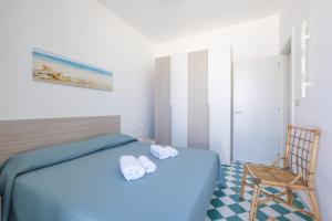 a bedroom with a blue bed with towels on it at Sea View Penthouse-Attico in Baia Verde