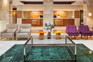 a lobby with purple chairs and a glass table at Sol Guadalmar in Málaga