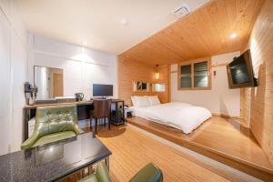 a bedroom with a bed and a desk with a television at Hotel S Shinchon in Seoul