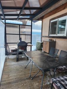 a screened in porch with tables and chairs and a grill at Shinsun Noelum in Hongcheon
