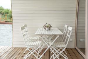 a white table and chairs on a porch at Lieblingsplatz Parey - schwimmendes Seehotel in Parey