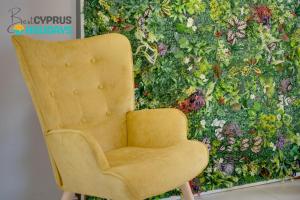 a yellow chair sitting in front of a wall at Lemon Paradise City centre 200m from beach in Larnaca