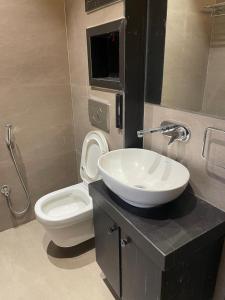 a bathroom with a white sink and a toilet at The Divine Villa! in Indore +11 photos
