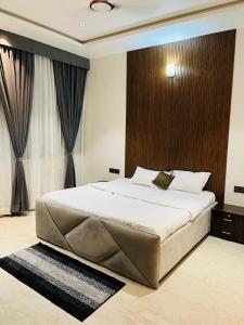 a bedroom with a large bed with a wooden headboard at The Divine Villa! in Indore