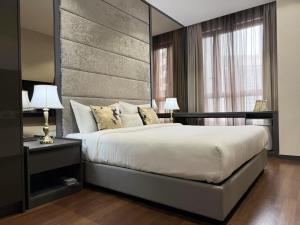 una camera da letto con un letto grande con una grande testiera di 8 Kia Peng KLCC by WSD a Kuala Lumpur Altre 30 foto