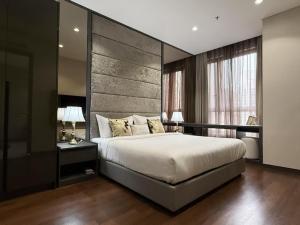 una camera da letto con un letto grande con una grande testiera di 8 Kia Peng KLCC by WSD a Kuala Lumpur